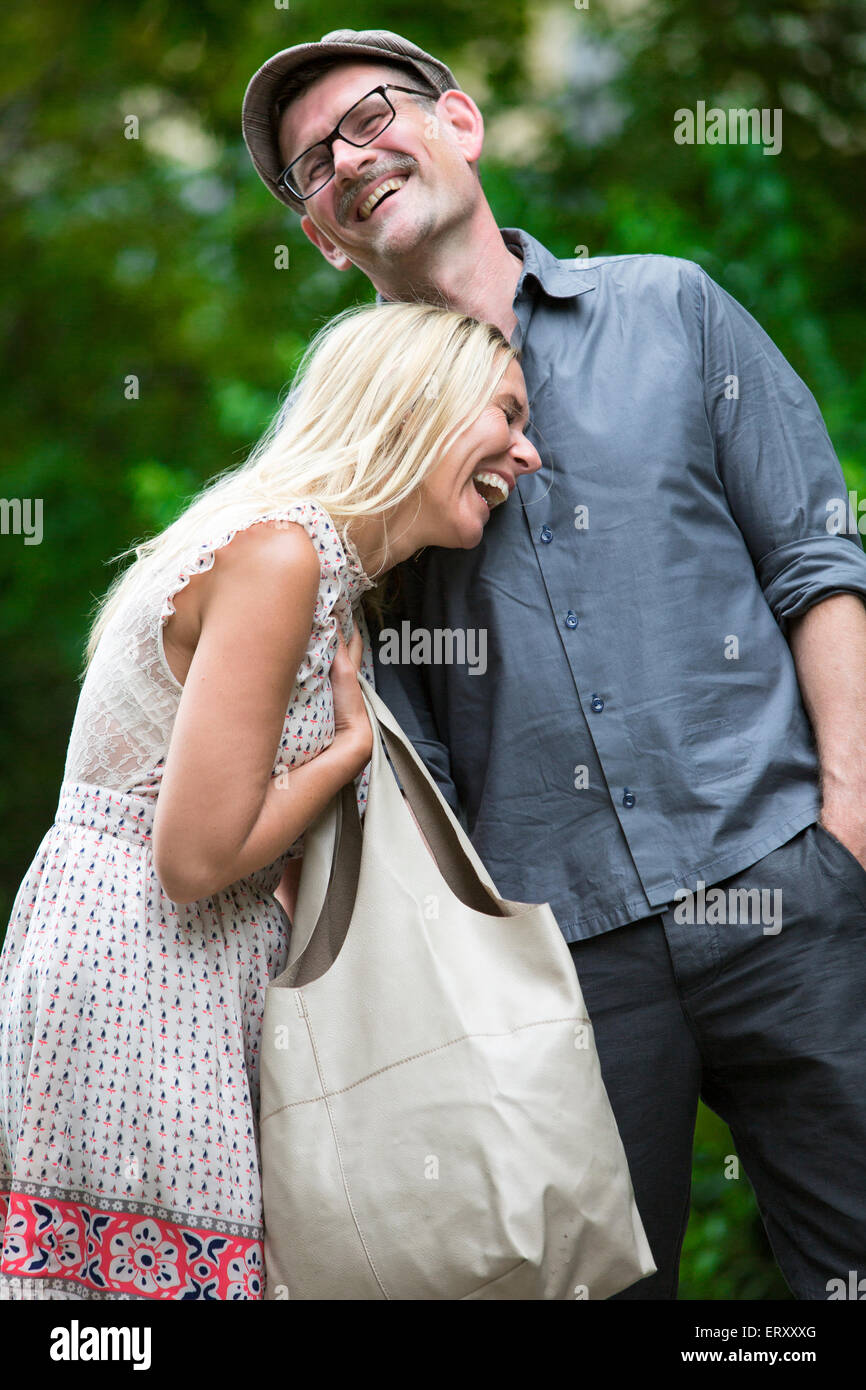 couple walking in a park and laughing Stock Photo - Alamy