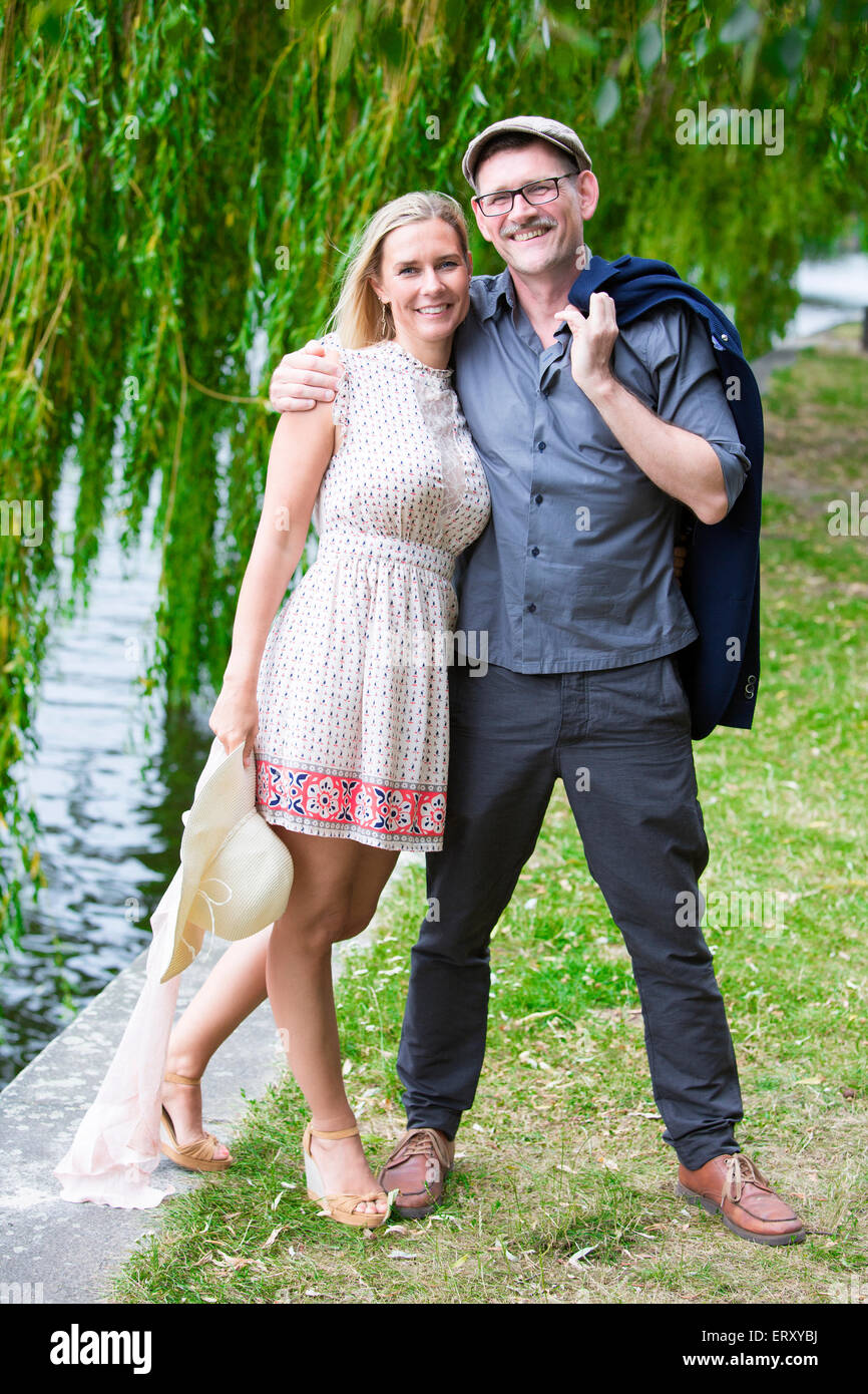 couple walking in a park alongside the water Stock Photo - Alamy