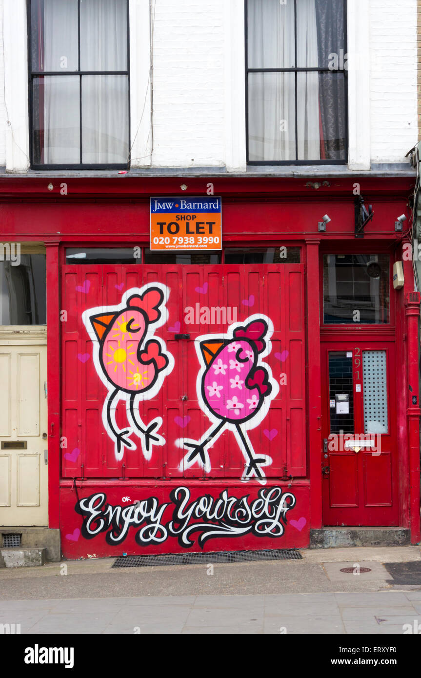 Enjoy Yourself graffiti by Binty Bint on a closed shopfront in Portobello Road. Stock Photo