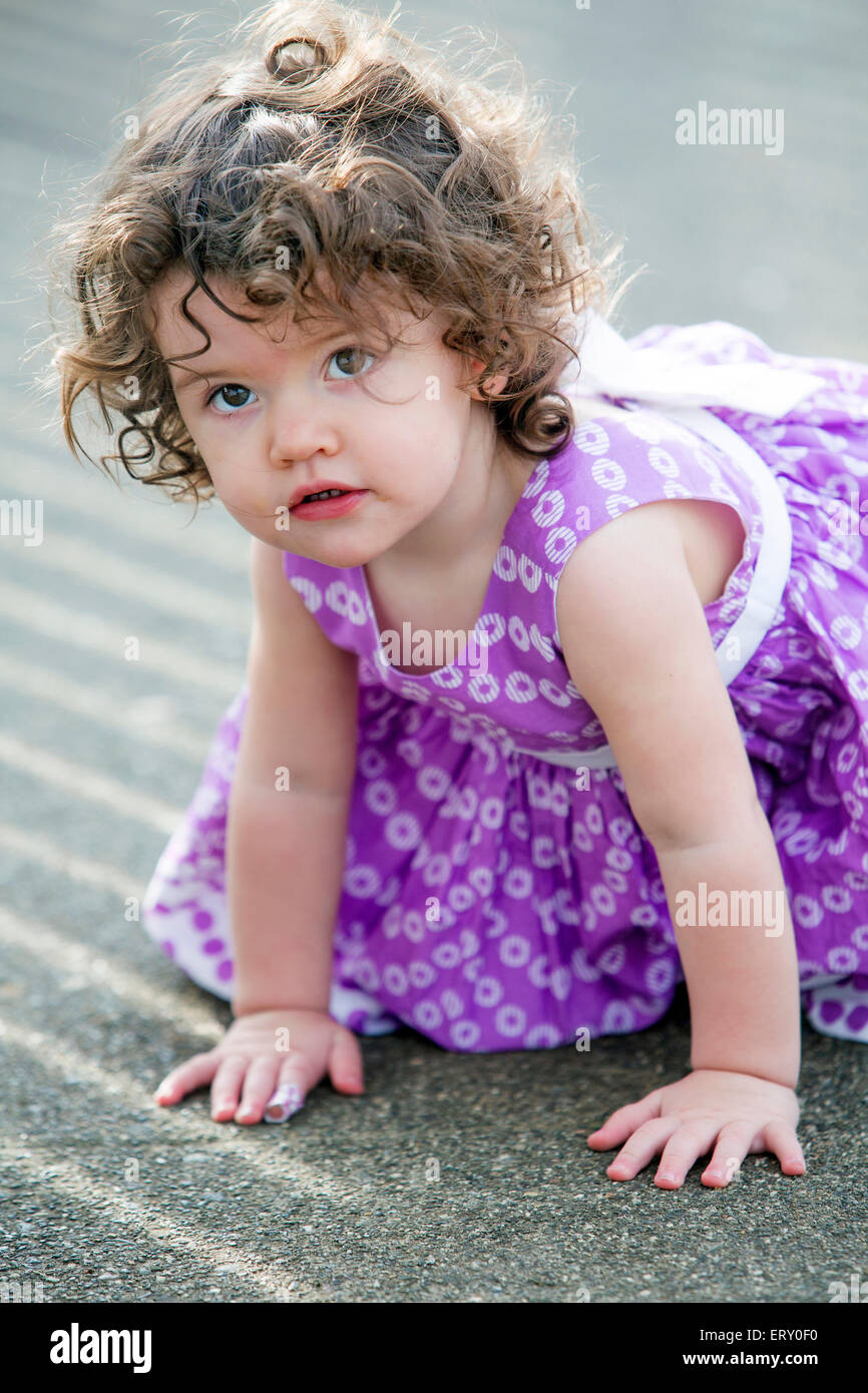 little girl in pink dress sitting on street Stock Photo - Alamy