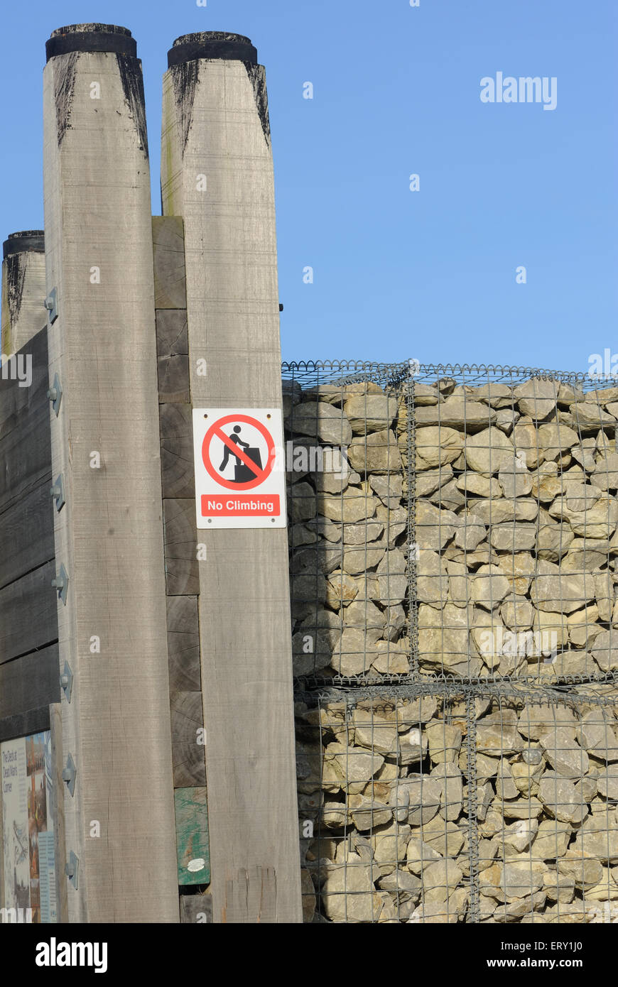 No climbing sign on  gabion and timber sea defences. Whitstable, Kent, UK Stock Photo