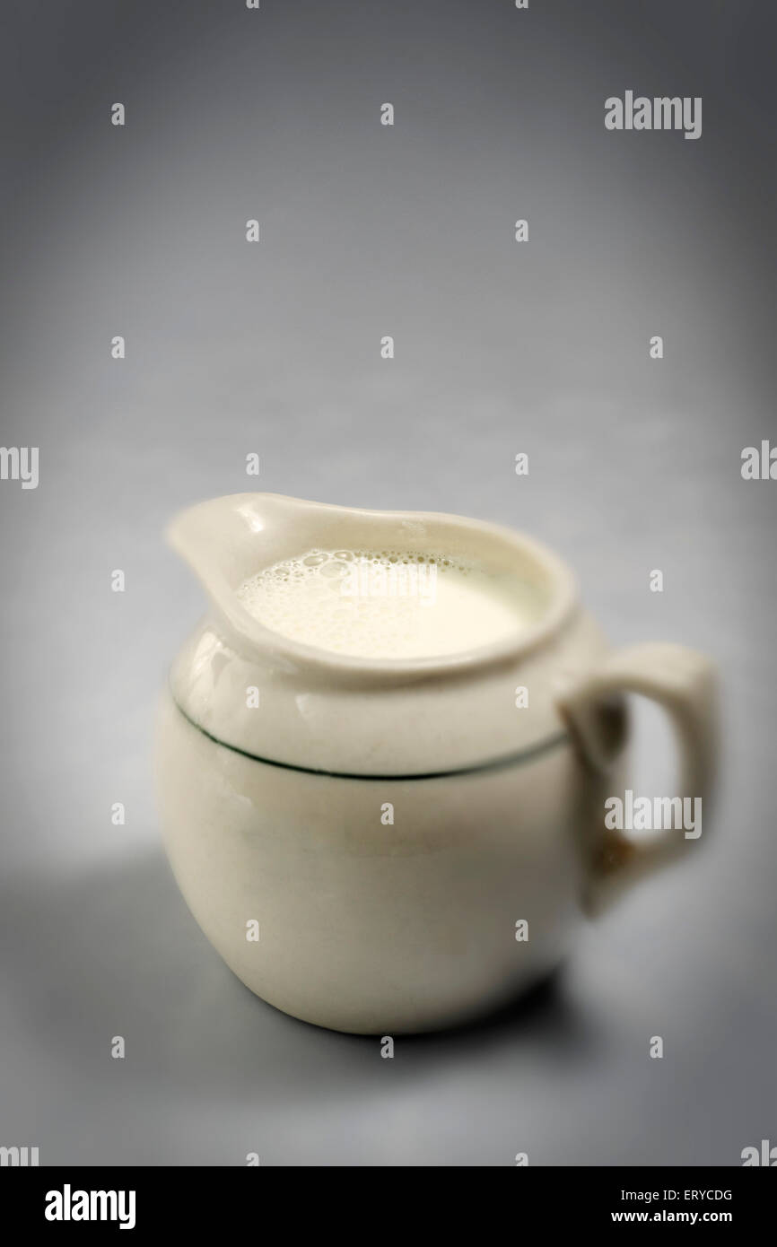 milk in ceramic jar on gray background Stock Photo