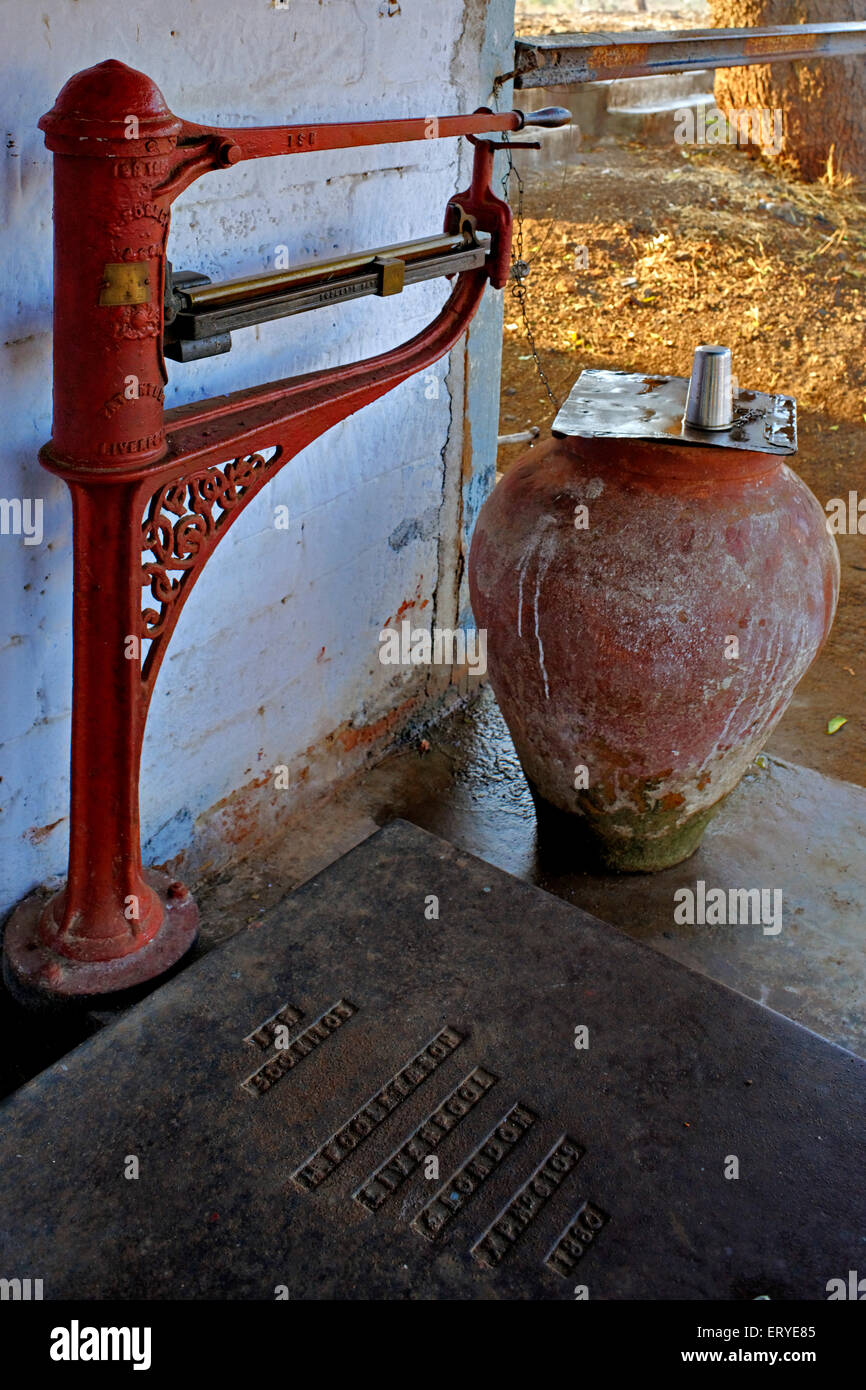 Old manual weighing scale and water pot on platform , Lunidhar , Mota Devaliya , Babra Taluka , district Amreli ; Saurashtra ; Gujarat ; India , Asia Stock Photo