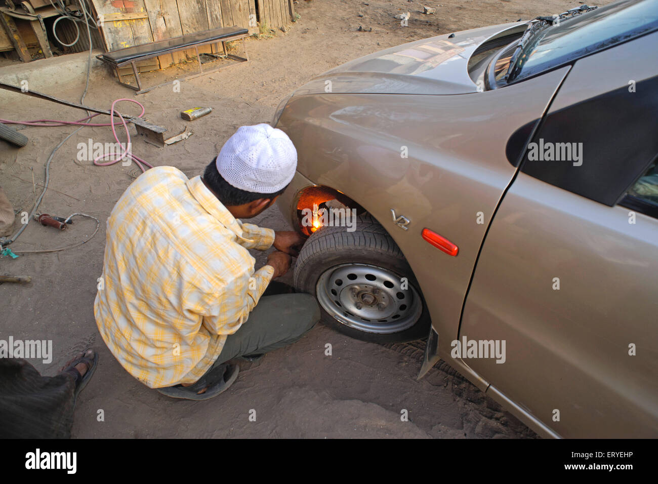 Man repairing doing welding work on car ; Sangamner ; Ahmednagar , Maharashtra ; India , asia Stock Photo