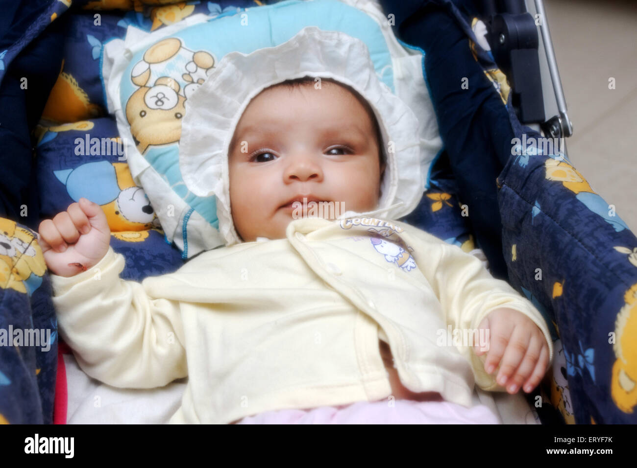 baby in pram ; Two month old Indian baby girl lying in pram , india , asia , MR#767 Stock Photo
