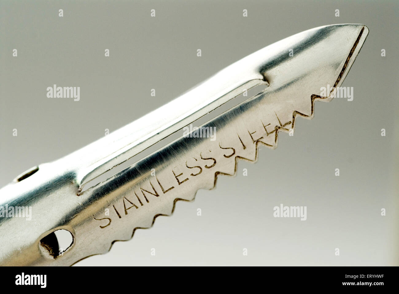 Stainless steel kitchen utensil peeler on gray background Stock Photo