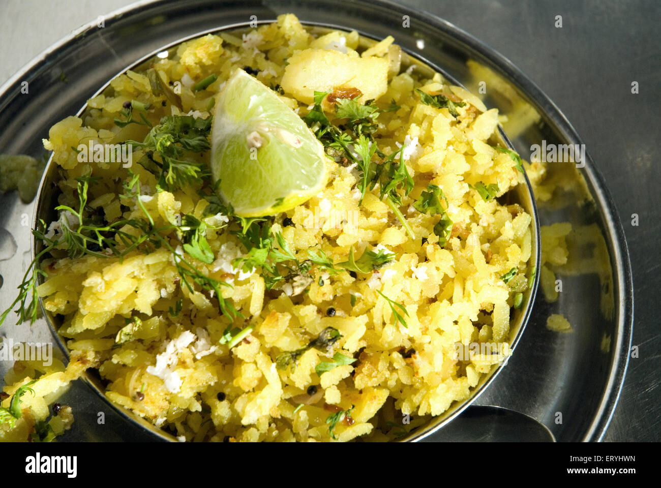 Pohe , Pohay , Poha , rice flakes with lime and coriander in steel dish Stock Photo
