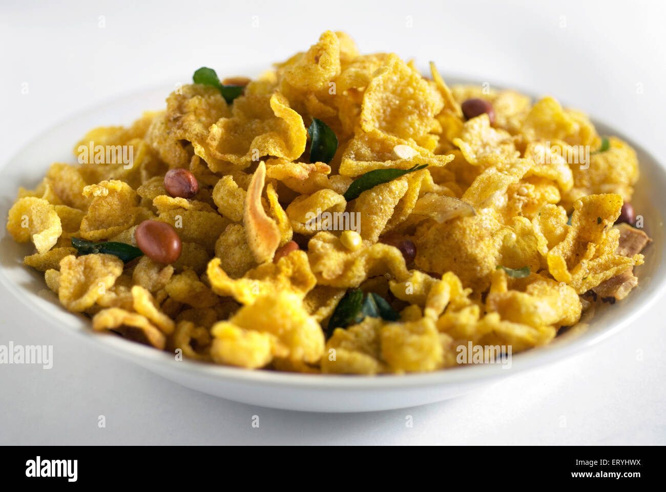 Snacks ; corn flakes fried yellow maka chivda served in dish on white background Stock Photo