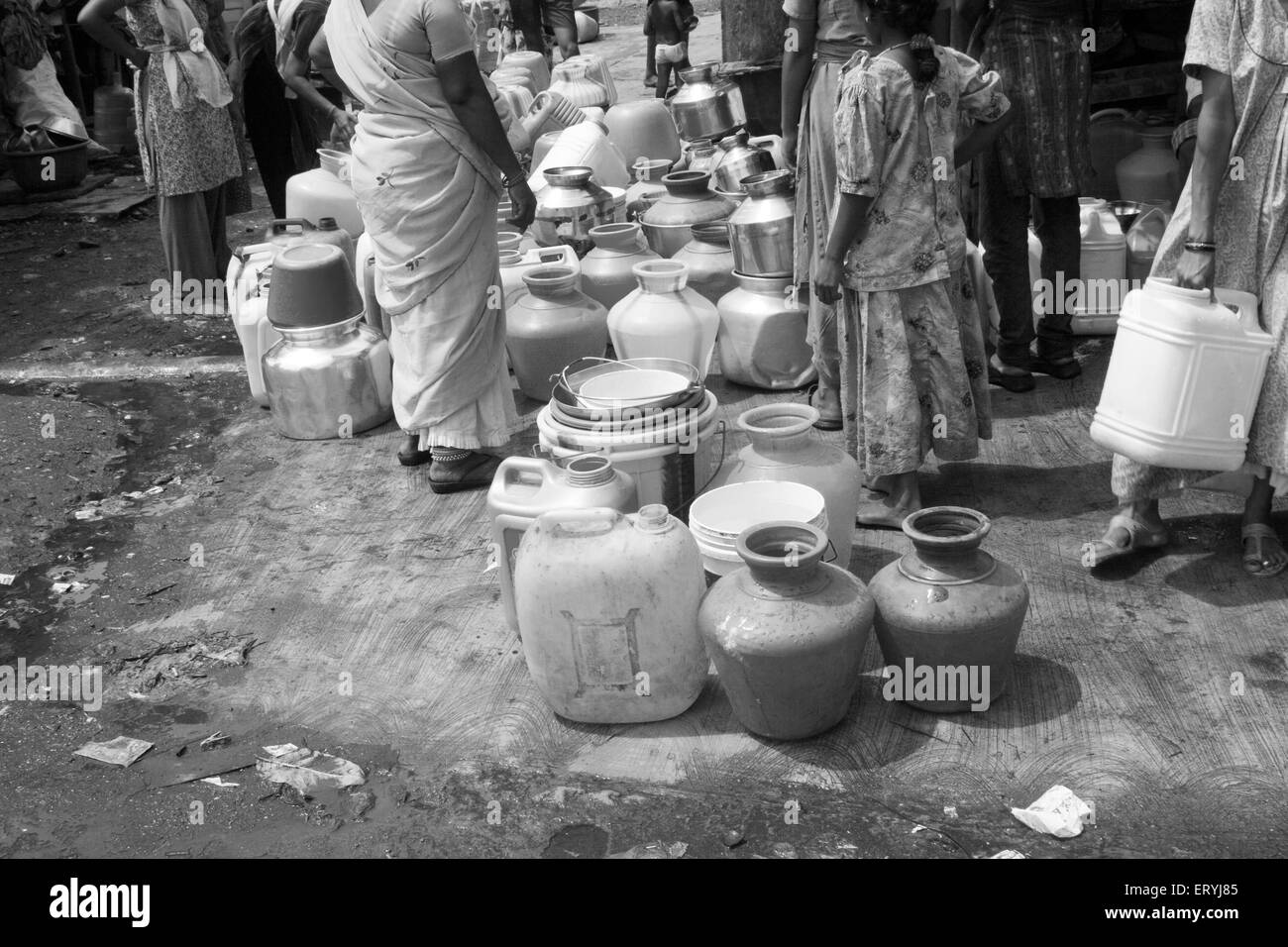 Queue for water in slum ; water shortage ; water scarcity ; water pots ; plastic pots ; Mahim ; Bombay ; Mumbai ; Maharashtra ; India ; Asia Stock Photo