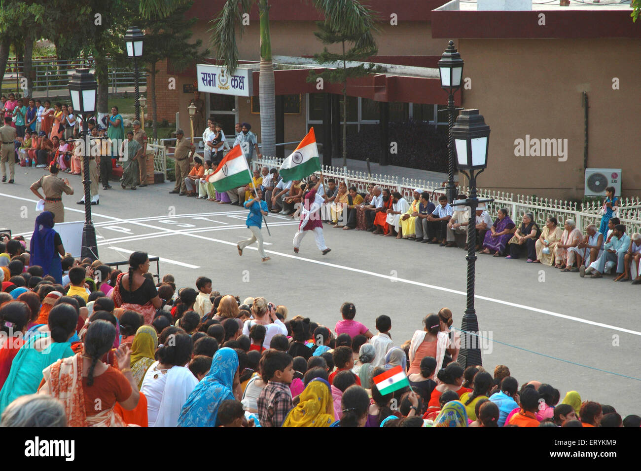 Tourists holding flags of India and running , Attari , Wagah border , Wahga , Wagha , Wahgah , Amritsar , Punjab , India , Asia Stock Photo