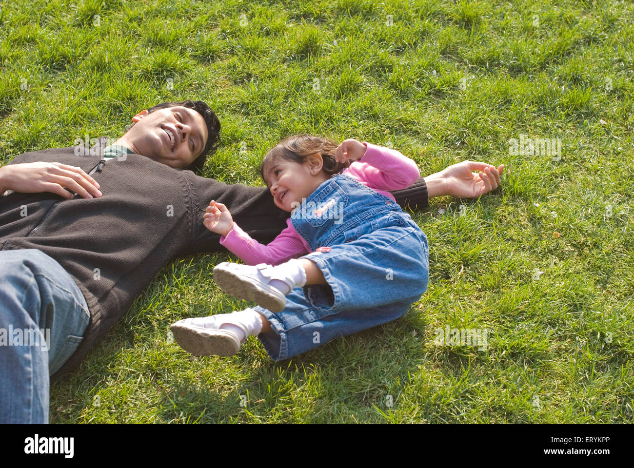 Father and daughter playing and enjoying on green grass at Botanical Garden ; Brooklyn ; New York ; USA United States of America Stock Photo