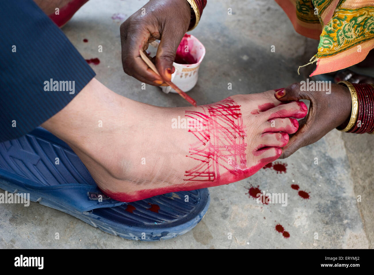 Hindu groom colouring feet with alta  India Asia Stock Photo