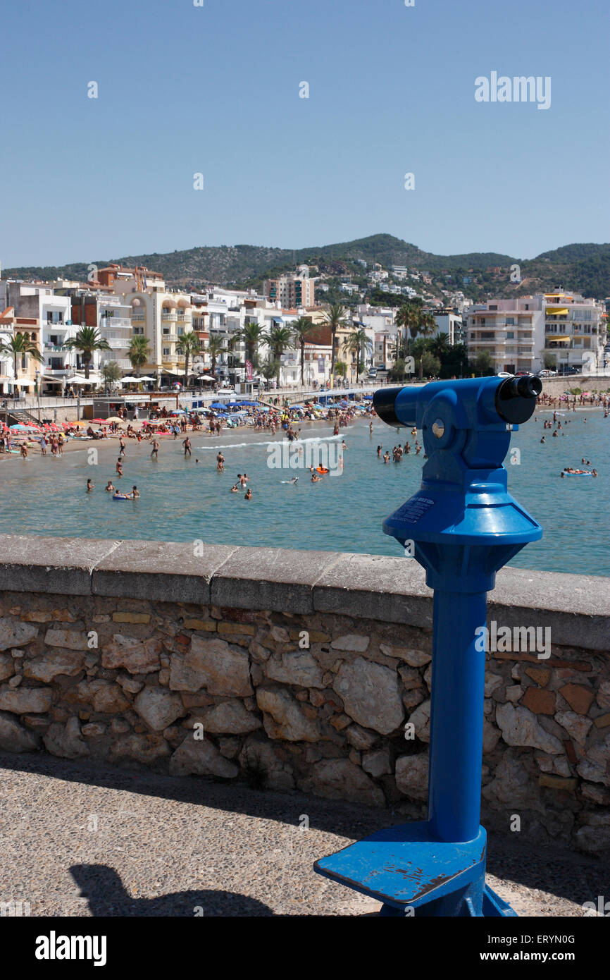 Coin operated telescope overlooking the crowded beach at Sitges, Catalonia, Spain Stock Photo