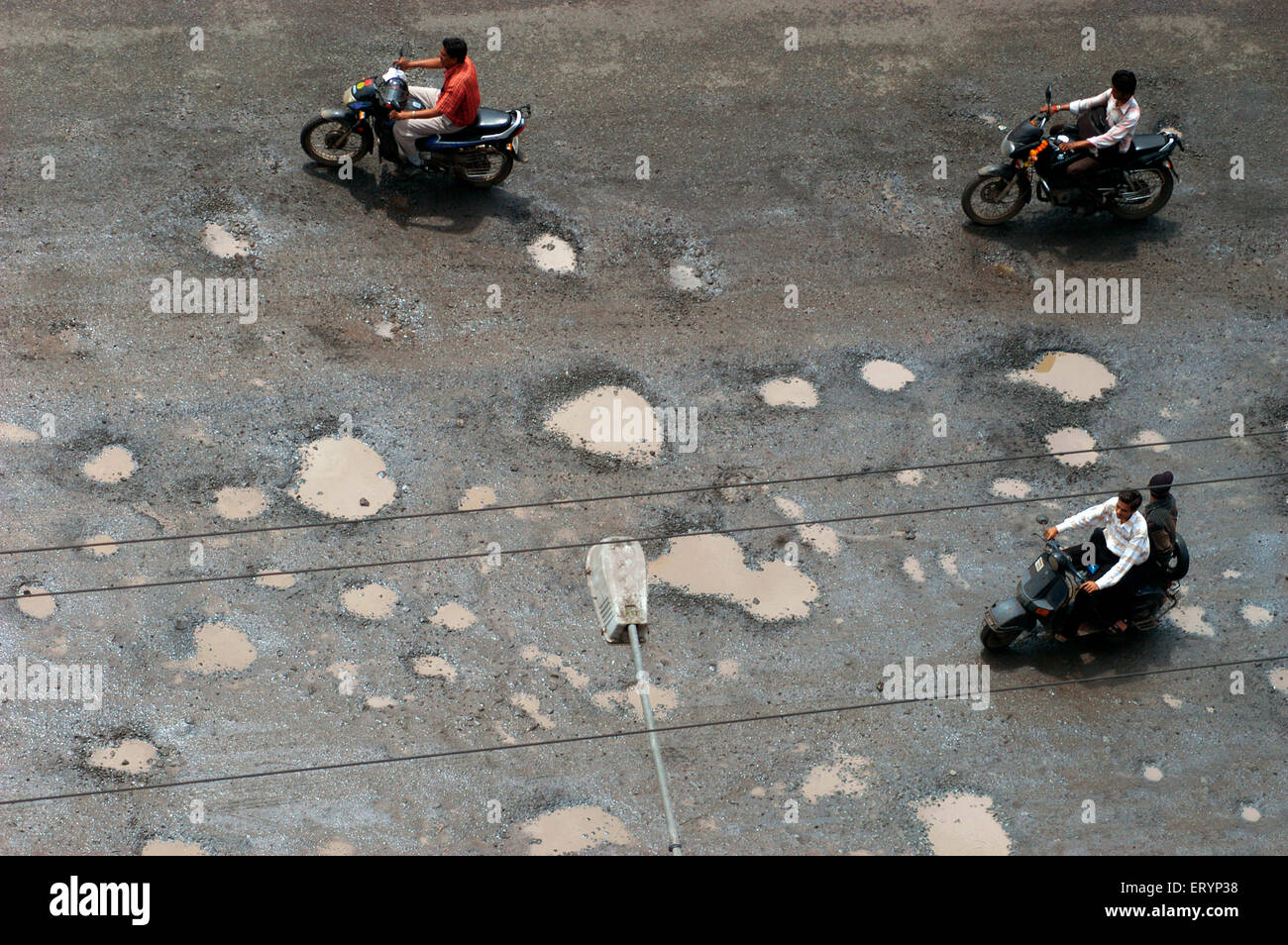 Two wheelers take treacherous journey in monsoon on Ghodbunder road in Thane ; Maharashtra ; India Stock Photo