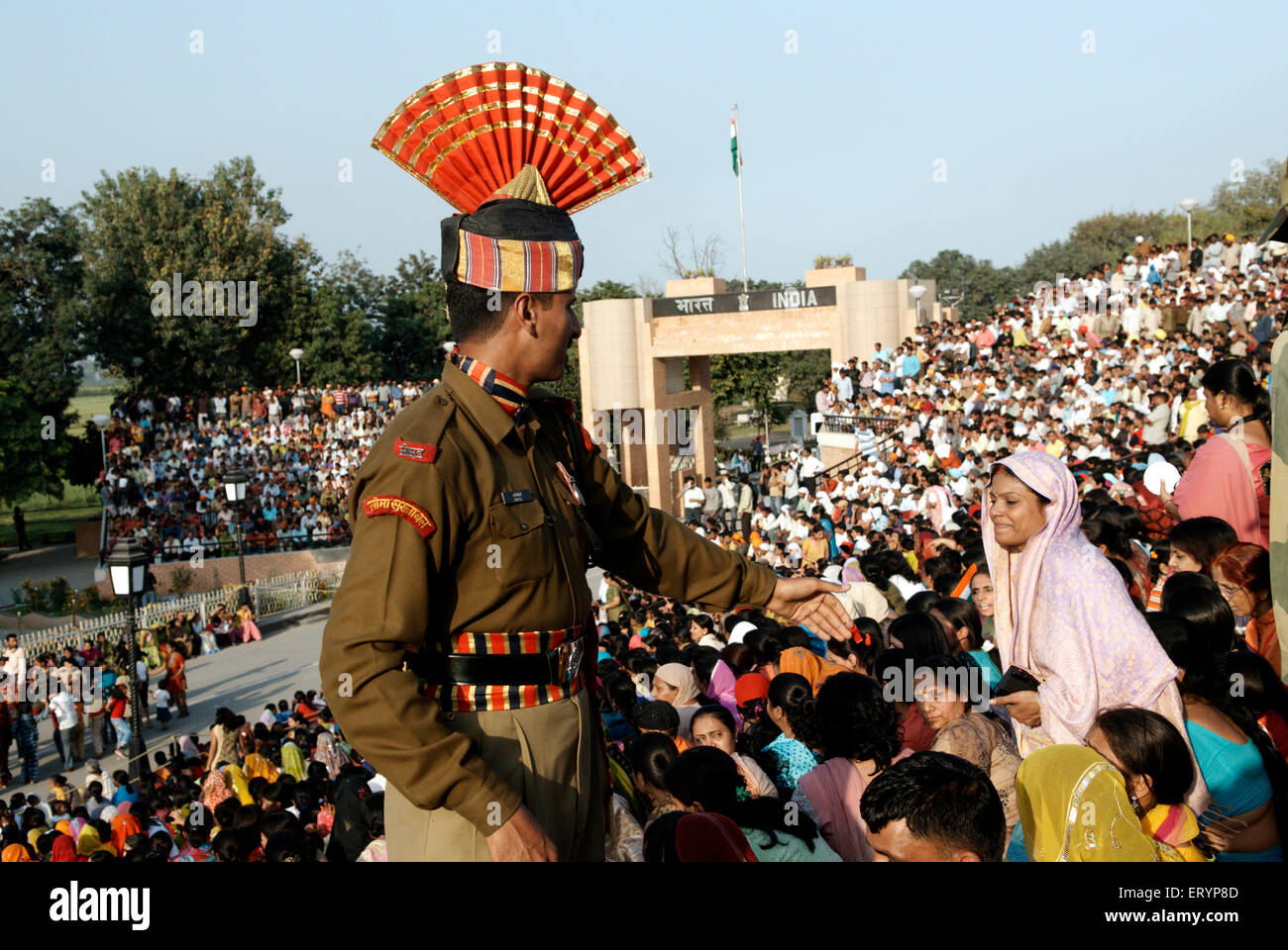 Indian Border Security Force soldier helping audience before retreat ceremony called lowering flags Stock Photo