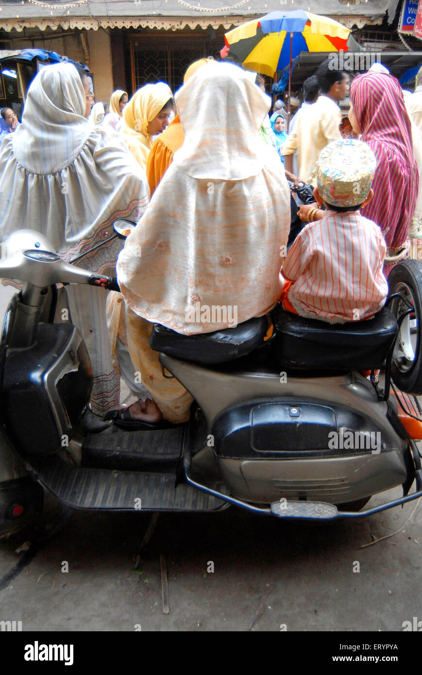 Dawoodi Bohra muslim lady and child sitting on scooter ; Bombay Mumbai ; Maharashtra ; India Stock Photo