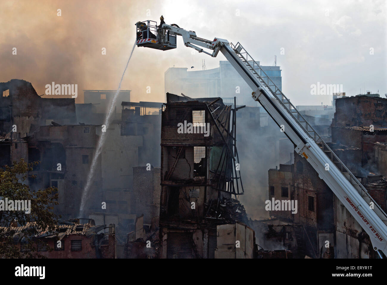 Firefighters dousing fire using snorkel in Behrampada slums ; Bandra ; Bombay Mumbai ; Maharashtra ; India 18 June 2009 Stock Photo