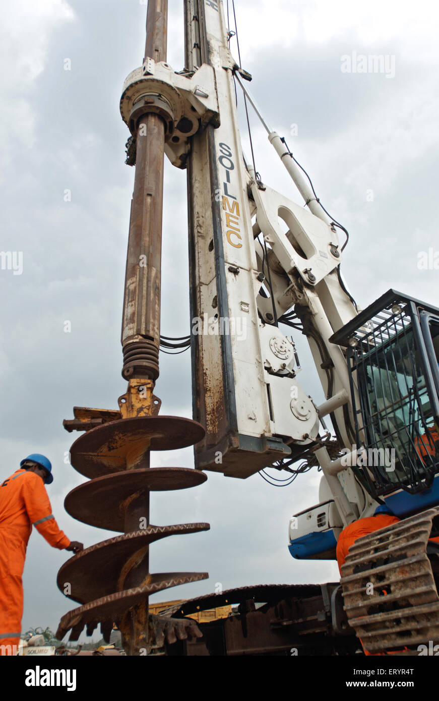 Worker cleaning Soilmec drilling machine , Madras , Chennai ; Tamil Nadu ; India , Asia Stock Photo
