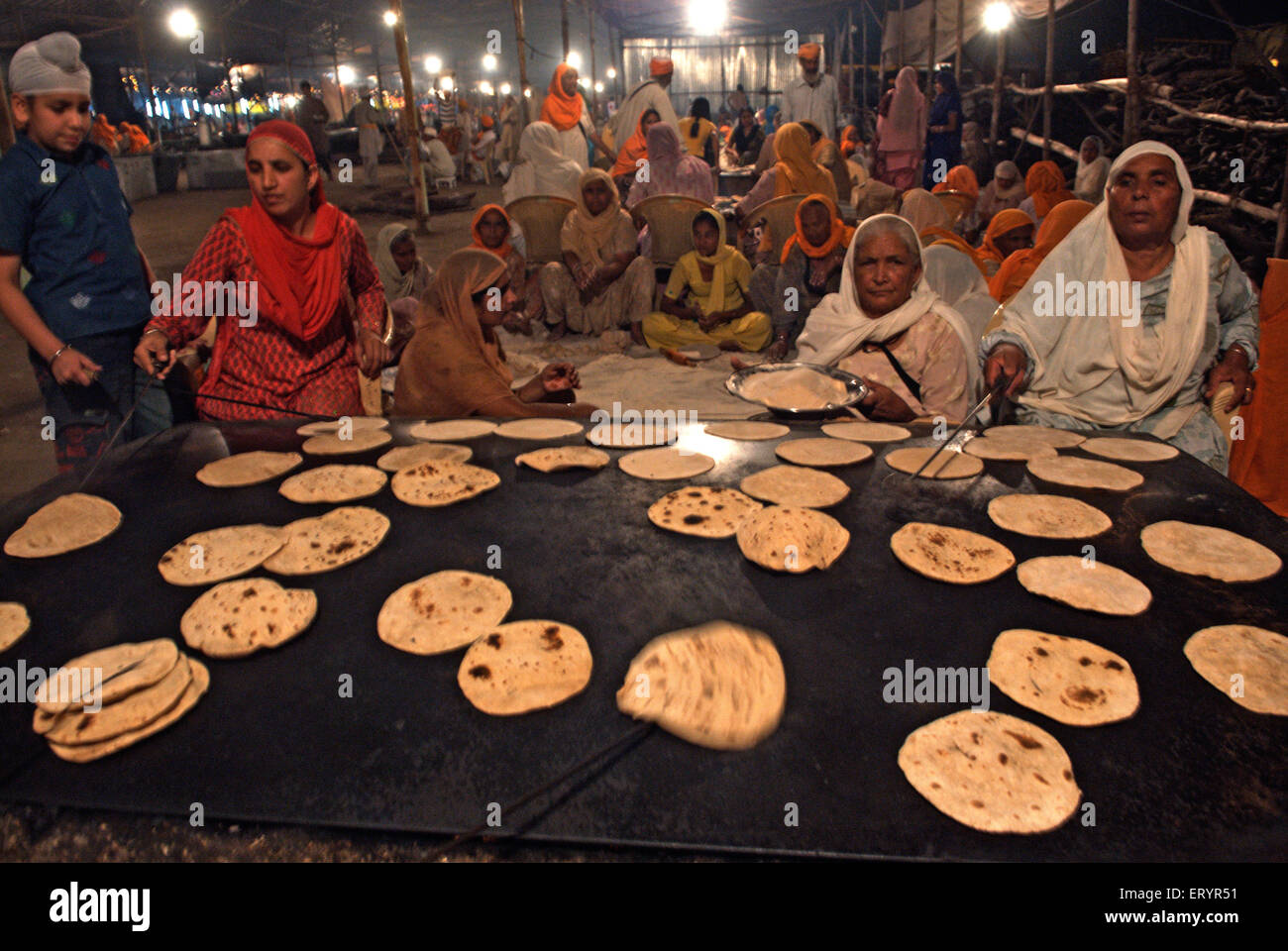 Women cooking making roti , Sachkhand Sahib Gurudwara , Nanded ; Maharashtra ; India , asia Stock Photo