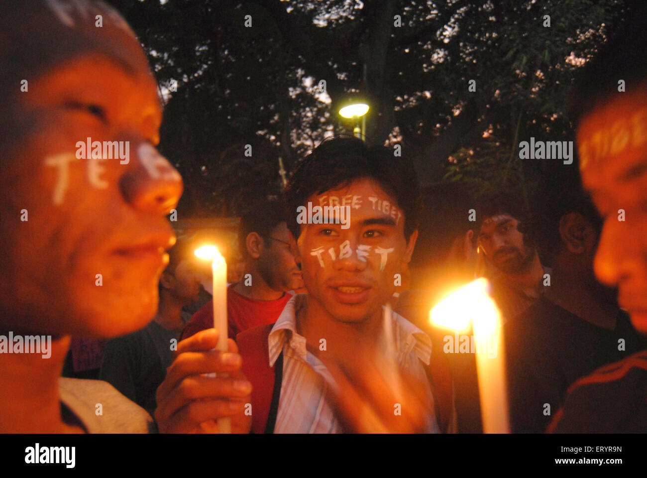 Free Tibet written on face, Buddhists protesting against China holding candles, Bombay, Mumbai, Maharashtra, India, Asia Stock Photo