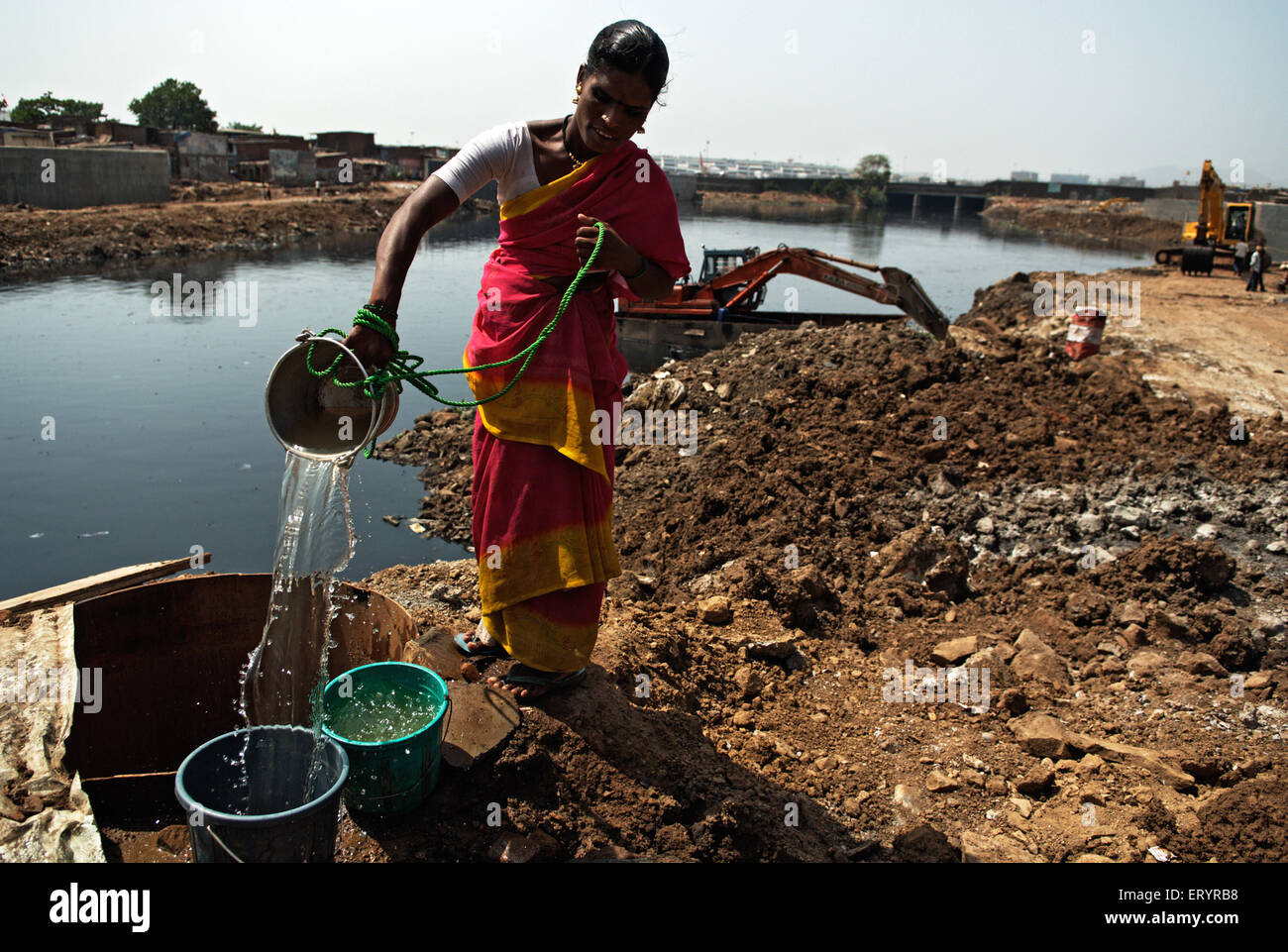 Woman collecting water from Mithi river ; Bombay , Mumbai ; Maharashtra ; India , asia Stock Photo