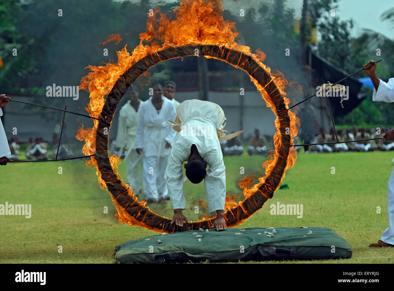 Policemen jumping through flaming hoop , Marol ; Bombay , Mumbai ; Maharashtra ; India , asia Stock Photo