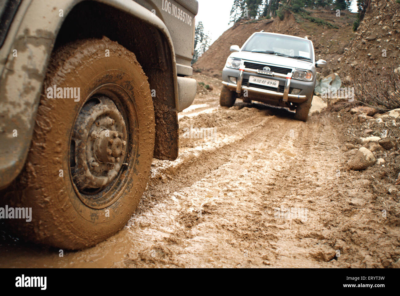 Cars on muddy under construction Mughal Road ; Poonch to Shopian , Jammu and Kashmir ; India , Asia Stock Photo