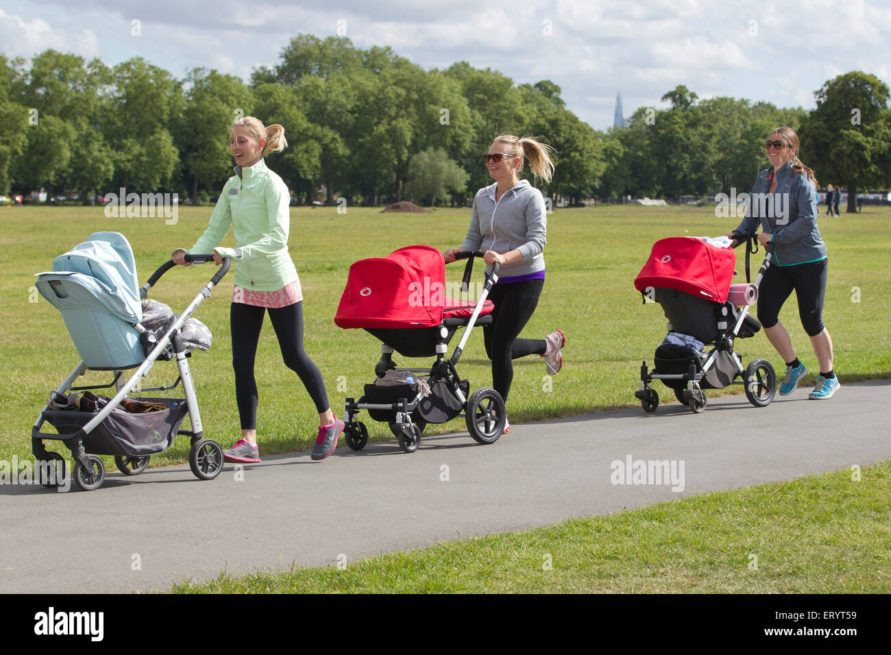 Mother's taking an exercise class with baby and toddler's in their buggies at a park in London, England, UK Stock Photo