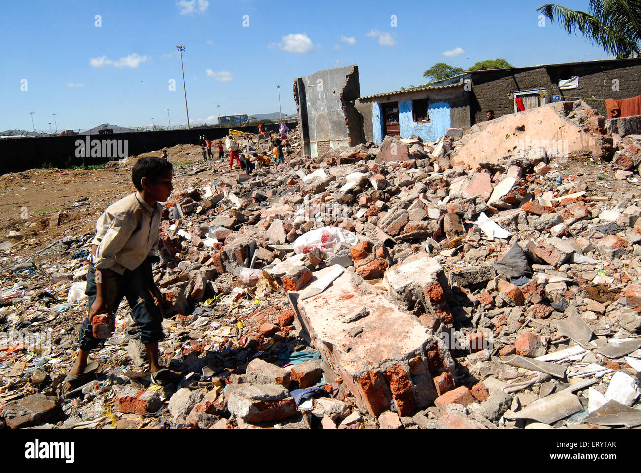 Mumbai slums , boy collecting bricks of his house after slum demolition , Sahar airport , Chatrapati Shivaji International airport , Bombay , Mumbai , Stock Photo