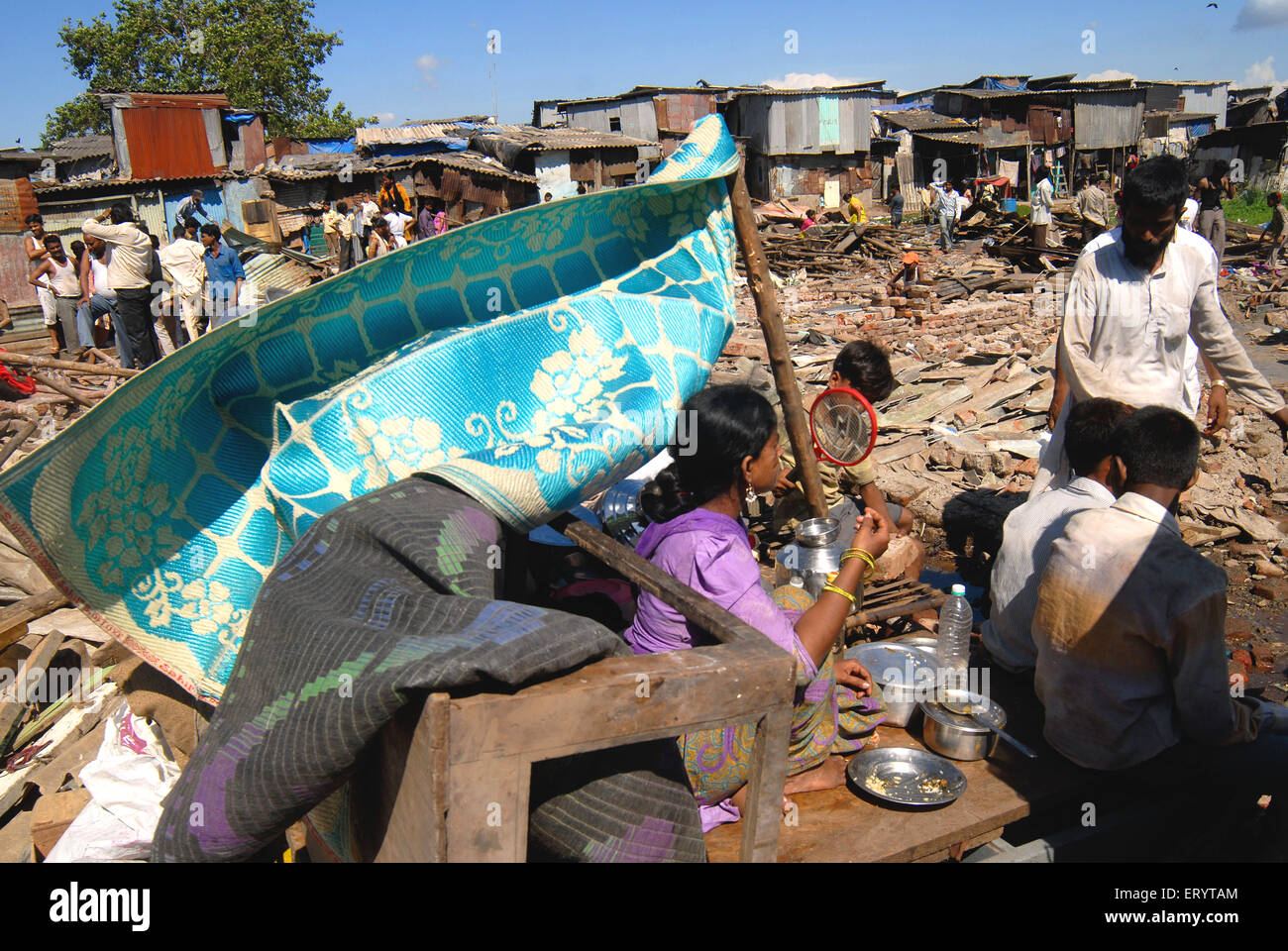 Slum dwellers sit with their belongings after demolition of slums on Sahar airport Chatrapati Shivaji International airport Stock Photo
