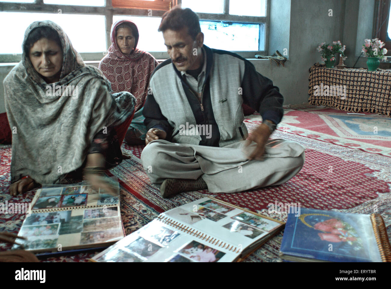 Kashmiri family showing album in Urusa , Kupwara , Muzaffarabad , Jammu and Kashmir ; India , Asia Stock Photo