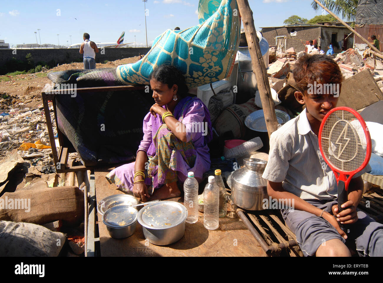 Slum dwellers sit with their belongings after demolition of slums on Sahar airport Chatrapati Shivaji International airport Stock Photo