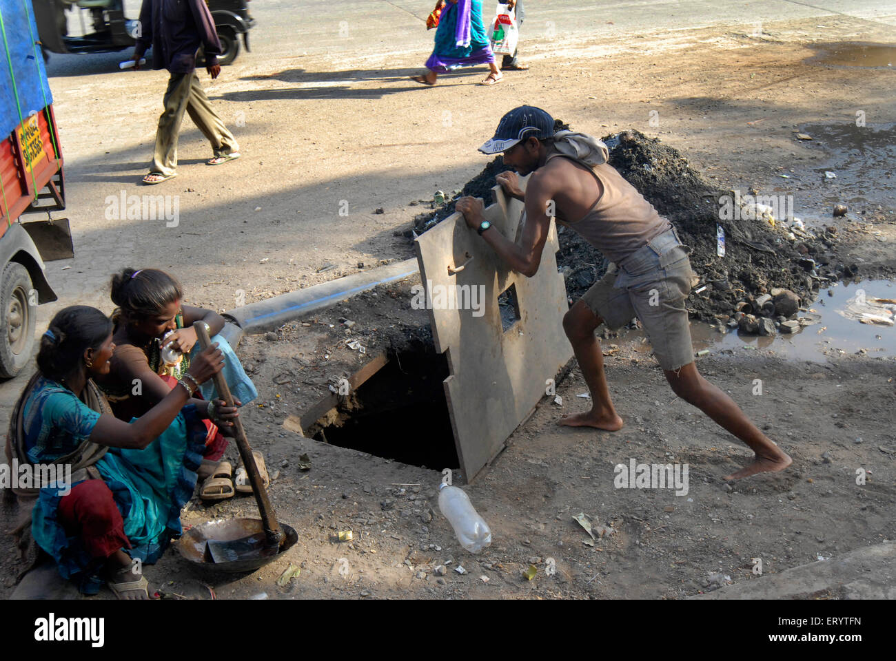 Man closing sewage drainage pipe cover after cleaning , Bombay , Mumbai