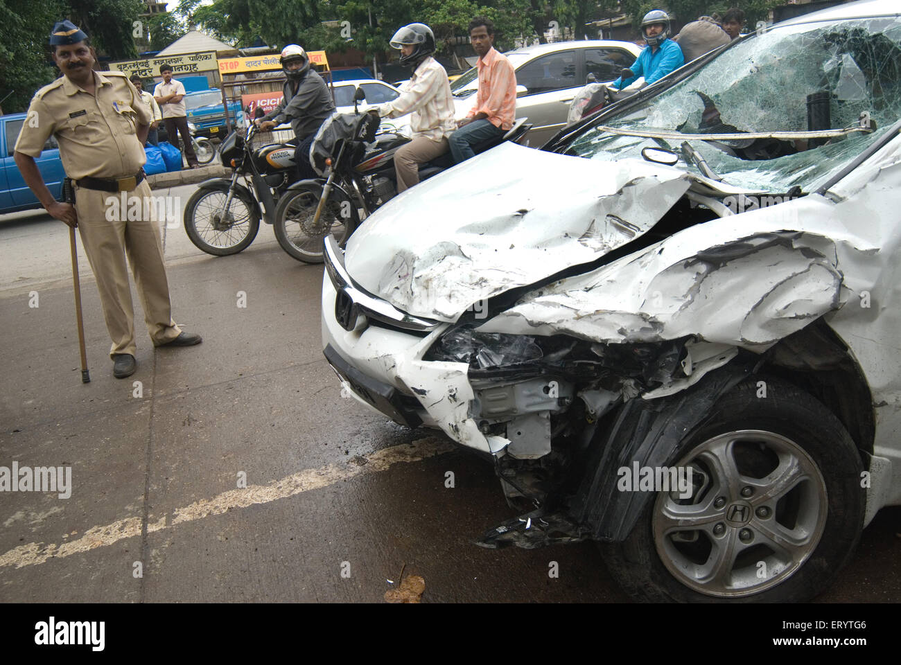 People watching car damaged in accident at Bombay Mumbai ; Maharashtra ; India Stock Photo