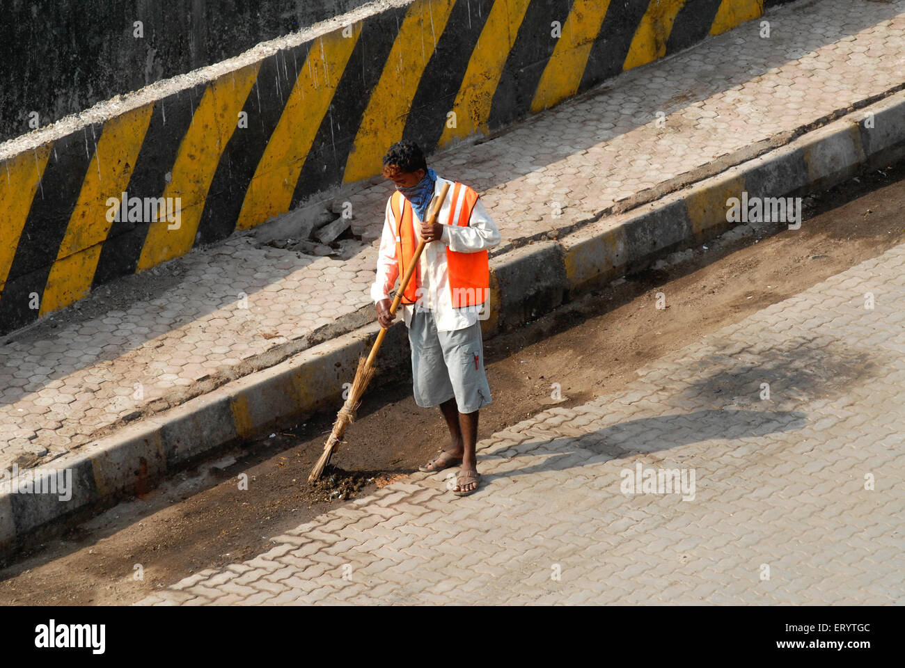 Sweeper cleaning sweeping road with broom , Bombay , Mumbai ; Maharashtra ; India , Asia Stock Photo