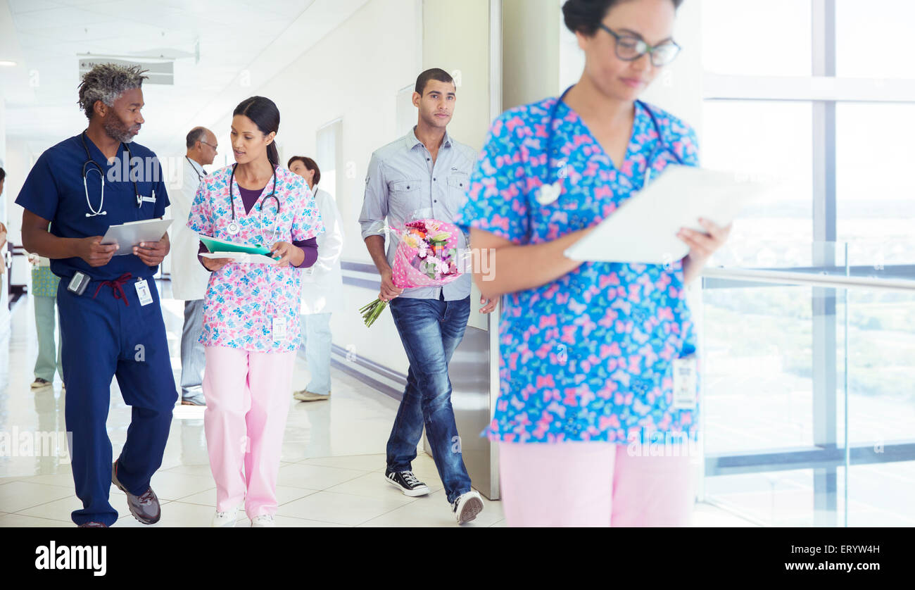 Doctor and nurse discussing medical record in hospital corridor Stock Photo