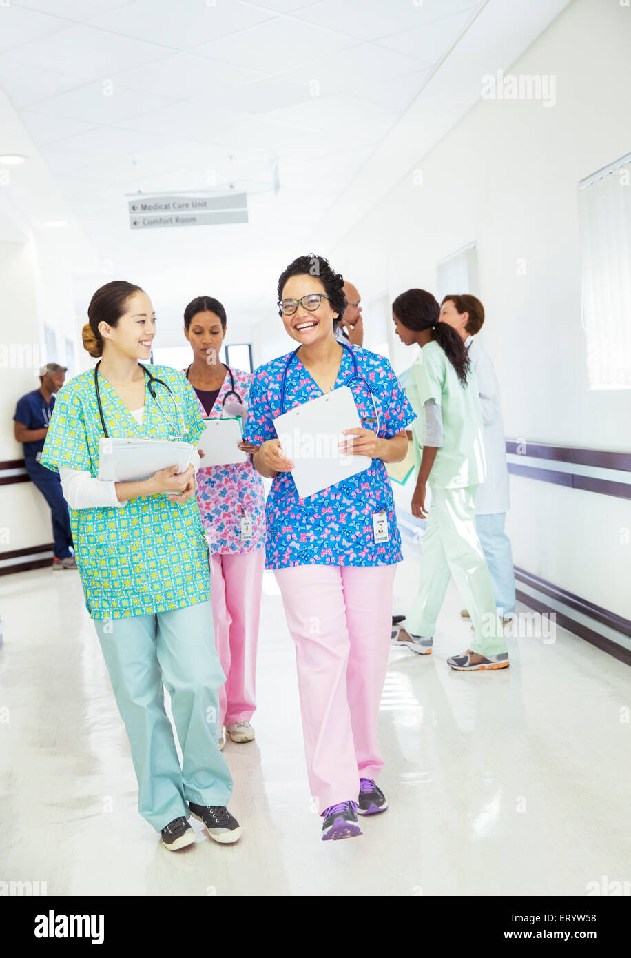 Smiling nurses talking and walking in hospital corridor Stock Photo