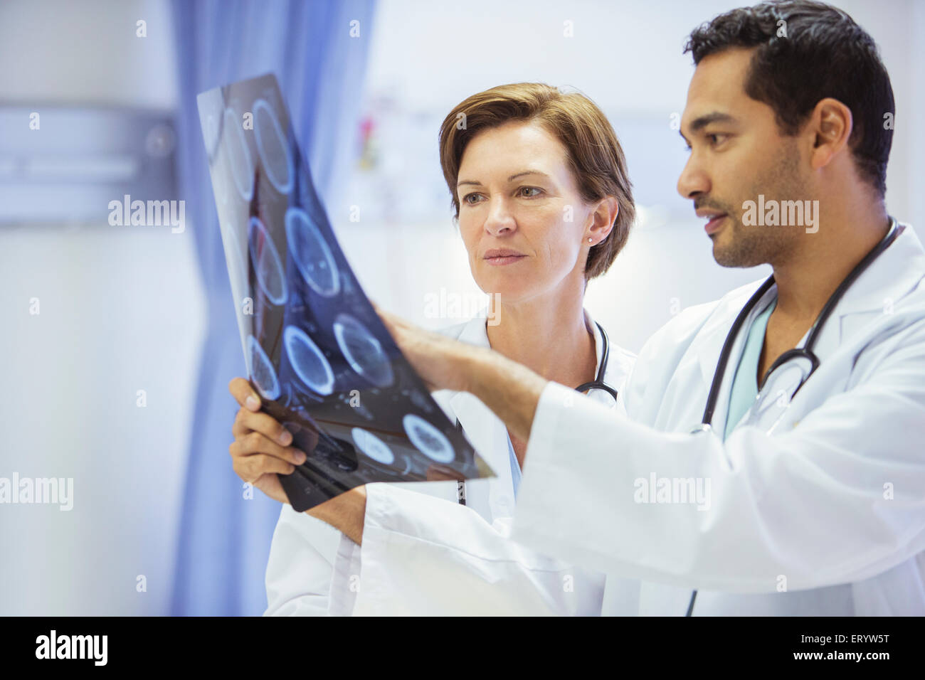 Doctors reviewing and discussing MRI scans in hospital Stock Photo