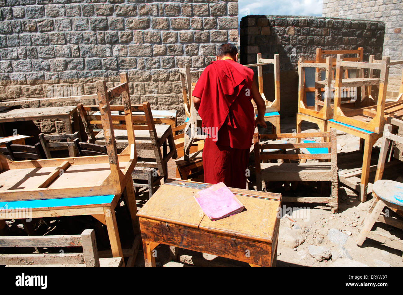 Monk searching books in damaged dpk institute due to flashflood in leh ; Ladakh ; Jammu and Kashmir ; India Stock Photo