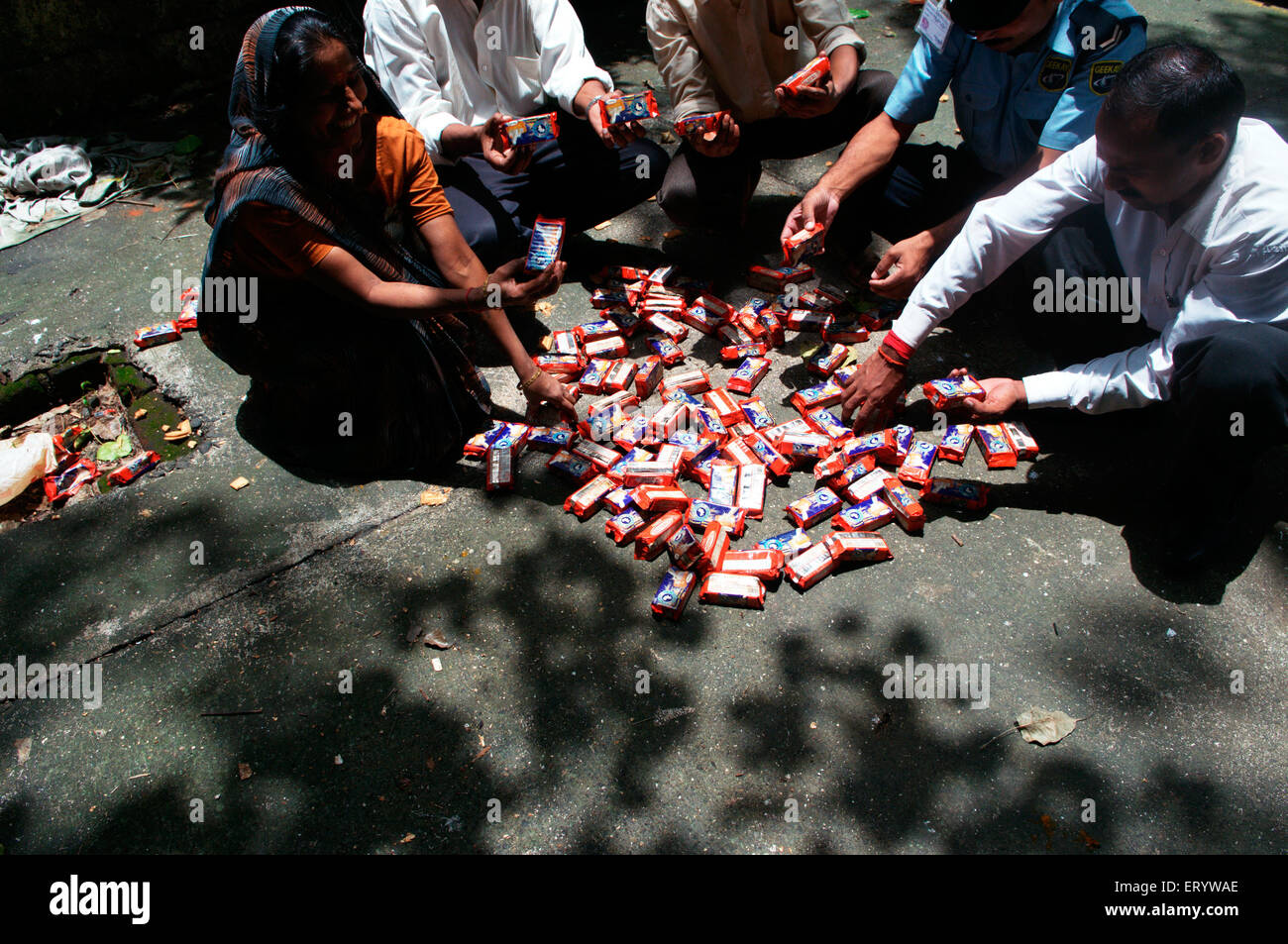 People sorting polluted biscuit packets due to container ship chitra colliding in sea Bombay Mumbai Stock Photo