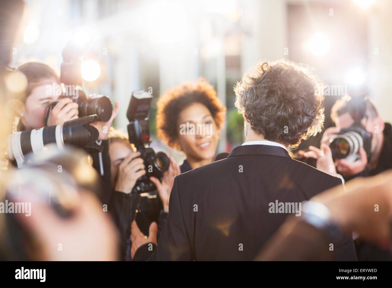 Celebrity being interviewed and photographed by paparazzi at event Stock Photo