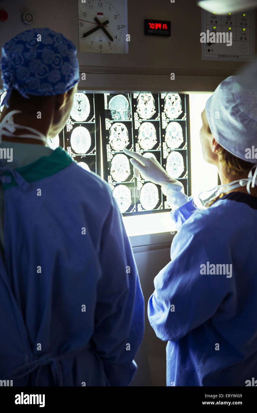 Surgeons reviewing and discussing MRI scans Stock Photo