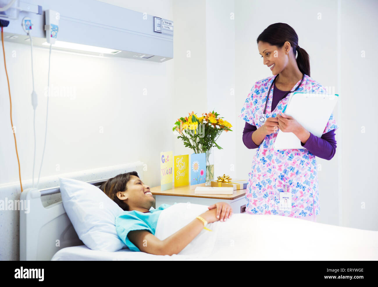Nurse talking to patient in hospital room Stock Photo