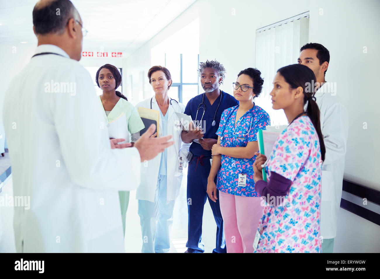 Doctor leading team meeting in hospital corridor Stock Photo