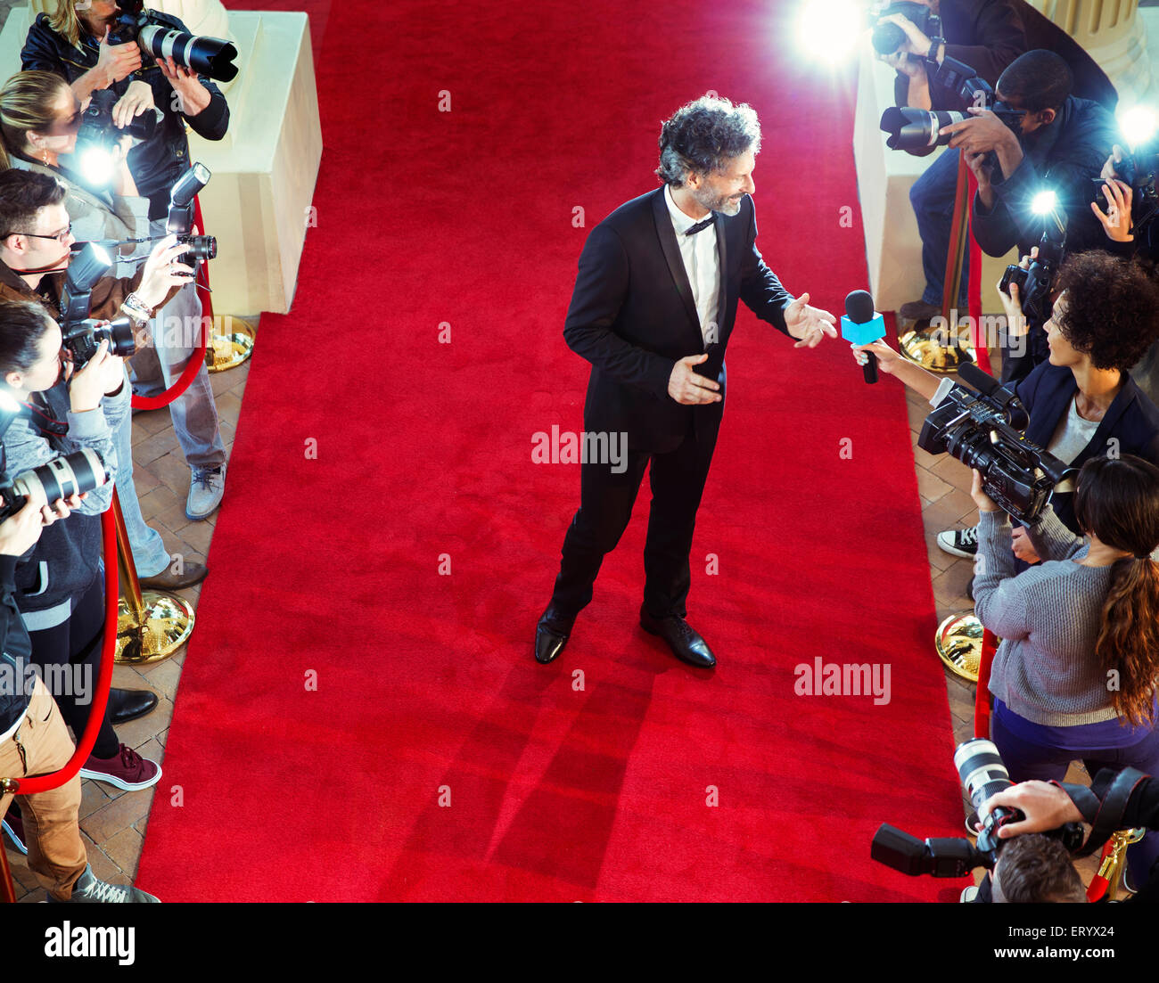 Celebrity on red carpet being interviewed and photographed by paparazzi Stock Photo