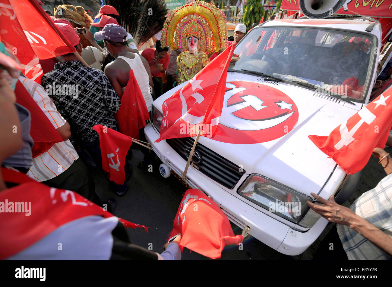 CPM Electioneering arrangement with Party flags and workers assembled  and Chhau Mask dancer at a place in Kolkata India Stock Photo
