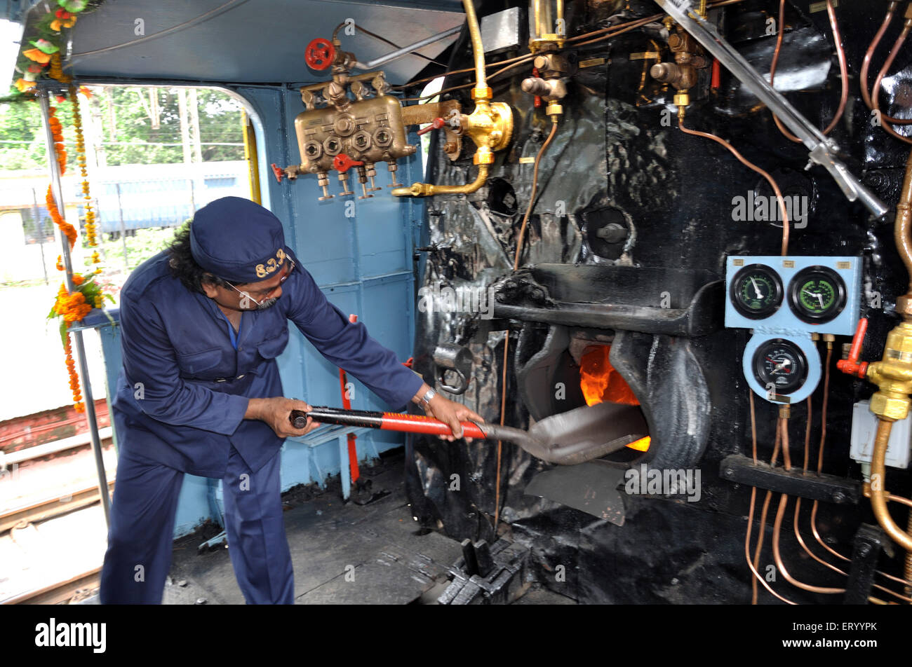 Firing with coal to engine by driver Stock Photo Alamy