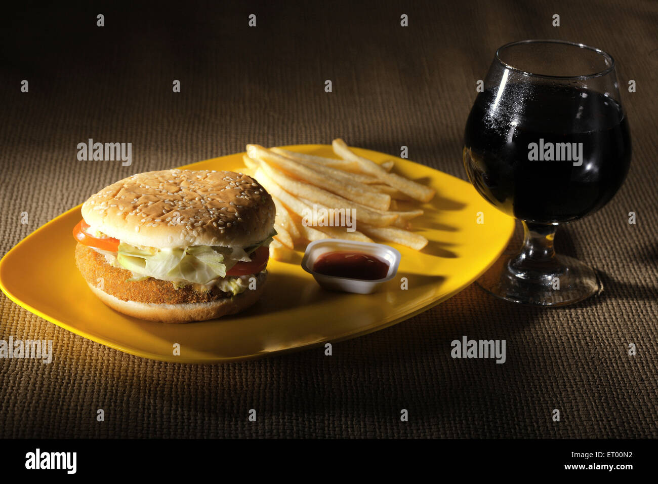 Fast food vegetarian burger with french fries with sauce and cola ; India Stock Photo