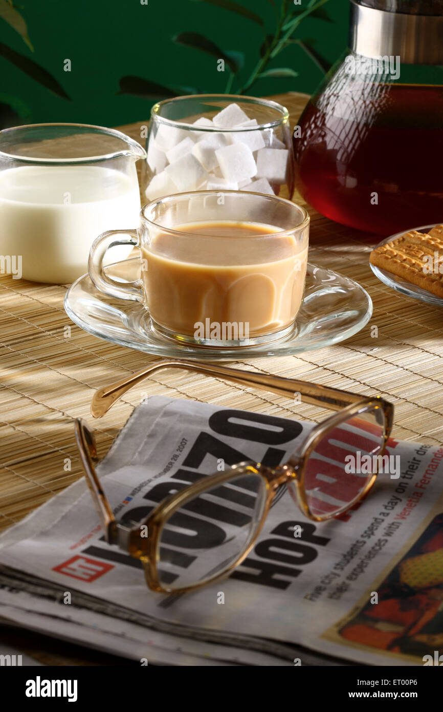 Tea time with biscuits and news paper ; India Stock Photo