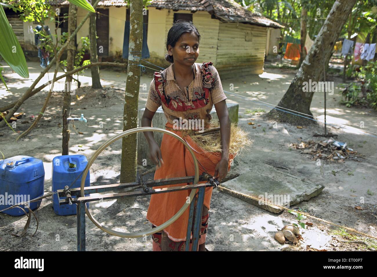 Keralite woman making coir rope in cottage ; traditional method